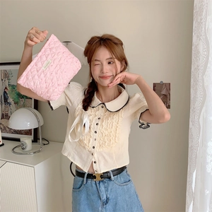 Detailed view of pink heart quilted cosmetic bag with zipper and branded label