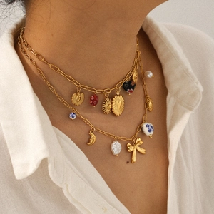 Double-layered gold necklace with sun, moon, and heart pendants worn by a model