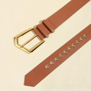 Detail of vintage brown leather belt with gold pentagon buckle and metallic eyelets