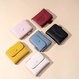 Flat lay of women's short bifold wallets in six colors with pebble grain faux leather