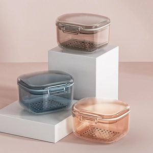 Three-layer orthodontic retainer box with drainage tray in amber and gray colors