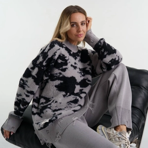Detailaufnahme des Strickpullovers mit Distressed-Optik, Rissen und Batik-Muster
