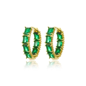 Detail of gold hoop earrings set with rectangular green zircon stones on white background