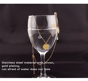 Macro detail of gold-plated stainless steel hammered pendant with zircon on black water glass