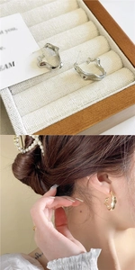 Boucles d'oreilles vagues irrégulières en or et argent portées par un mannequin