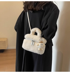 White faux shearling crossbody bag styled on a black coat with cute plush charm detail