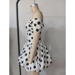Dettaglio mini abito a pois bianchi e neri con taglio a spalle scoperte e gonna a sbuffo