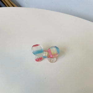 Macro view of butterfly acetate hair clip with colorful stripes and sparkling rhinestones