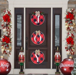 Close-up of JOY wooden signs and Merry Christmas ornaments on a festive front door