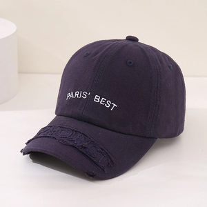 Detailed view of PARIS' BEST embroidery and distressed brim on navy cotton baseball cap