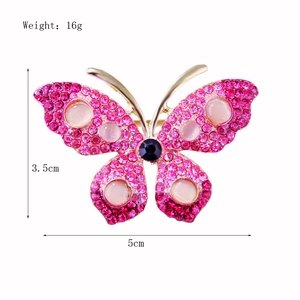 Detailed rhinestone butterfly brooch with pink cat's eye stone measuring 5cm x 3.5cm