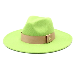 Detail of lime green wool fedora hat featuring a brown ribbon and gold bee emblem