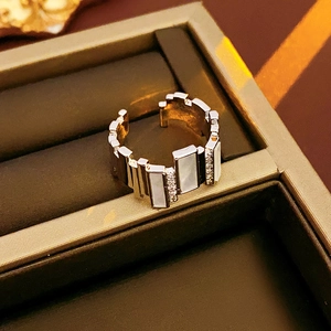 Macro view of irregular silver-plated open ring with zircon and mother-of-pearl inlay