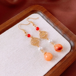 Detail of vintage flower tassel earrings with pearls and gold hollowed window design