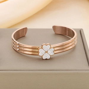 Détail d'un bracelet trèfle en or rose avec cristaux sur un écrin à bijoux