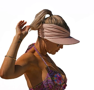 Detailed side view of a pink wide brim sun visor hat worn by a model for UV protection
