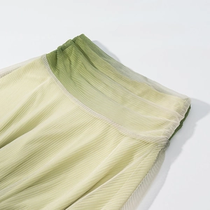 Detail of gradient mesh pleated waist with elastic band in green and light yellow tones