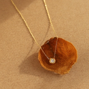 18K gold plated titanium necklace with hexagonal pendant and white zircon on dry petals