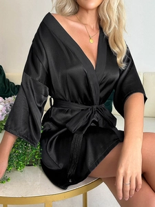 Détail d'un peignoir élégant en satin noir avec manches kimono et ceinture assortie