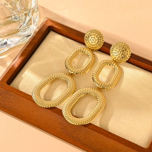 Vintage gold geometric earrings with textured dot patterns and layered oval design