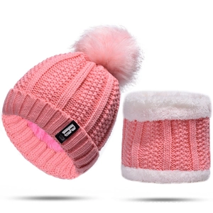Detailed view of pink knitted beanie with a large pompom and faux fur lined scarf set