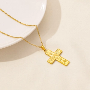 Detailed view of 18K gold plated cross necklace with sunflower relief on white ceramic