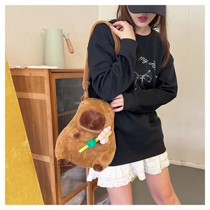 Cute brown capybara plush crossbody bag featuring a small pink flower on a female model