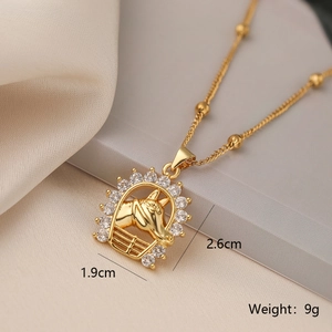 Macro detail of gold horse head pendant with cubic zirconia inlay 1.9cm x 2.6cm