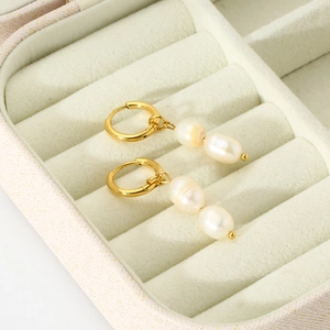 Macro detail of 14K gold plated earrings featuring baroque freshwater pearl drops in a gift box