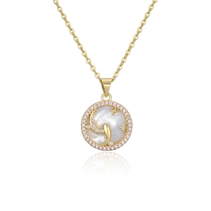 Macro detail of gold plated Pisces zodiac necklace with pink zircon and mother of pearl