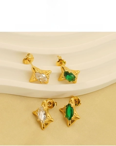 Macro detail of star-shaped earrings with emerald cubic zirconia in 18k gold plating