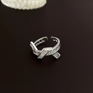 Macro shot of silver baguette-cut crystals on modern crisscross open adjustable ring