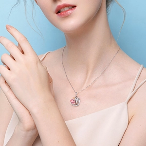 Silver unicorn heart pendant necklace with pink crystal on a female model