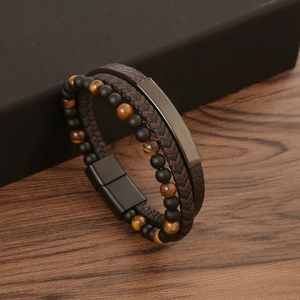 Detail of leather wrap bracelet with tiger eye stones and magnetic clasp on dark wood
