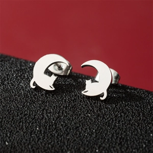 Minimalist stainless steel silver cat and moon stud earrings on a contrast background