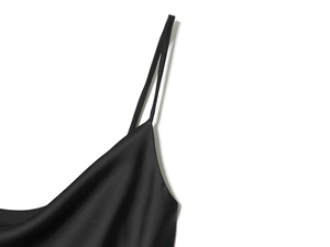 Detail of black satin slip dress showing elegant cowl neck and thin spaghetti straps