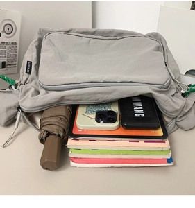 Spacious gray nylon messenger bag interior showing books, tablet, and umbrella storage
