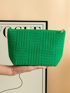 Green textured fabric makeup bag with top zipper closure and a minimalist design