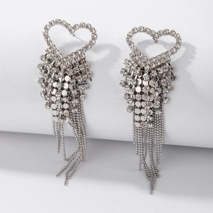 Close-up of silver heart fringe earrings with sparkling rhinestones and metallic tassels