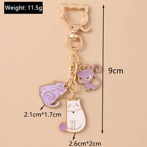 Detail of cute cat paw keychain featuring purple enamel charms and gold feline clasp