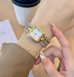 Detail of square silver and gold watch with mother of pearl dial and crystal markers