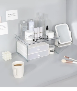 Detail of clear acrylic desktop organizer with white drawers and silver metal supports