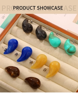 Détails de boucles d'oreilles en résine colorée en forme de goutte dans un écrin