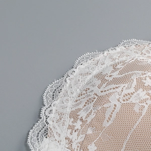 Détails de dentelle florale blanche avec doublure beige sur une robe bustier élégante
