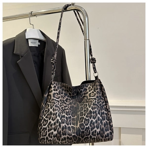 Detail of trendy leopard print tote bag featuring a decorative knotted shoulder strap