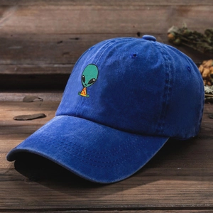 Close-up of green alien embroidery on washed navy blue cotton baseball cap fabric