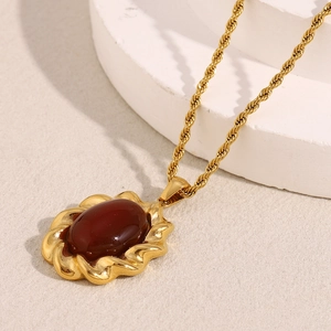 Détail macro de la chaîne torsadée plaquée or 18K et du pendentif en agate rouge ovale