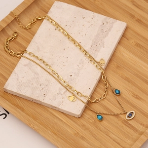 Gold-plated layered stainless steel necklace featuring blue evil eye and teardrop pendants