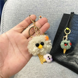 Plush ice cream cone keychain with cute monster face on a black bag