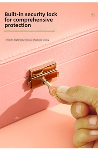 Detail of pink leather jewelry box featuring a gold security lock and matching key